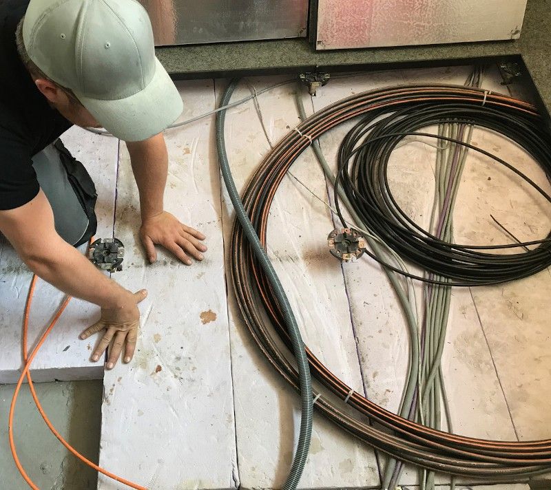 Electrical professional laying data cables under floor
