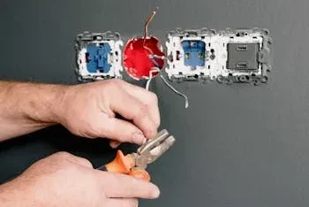 An Electrician Using Pliers to Repair the AC Power Plugs and Sockets