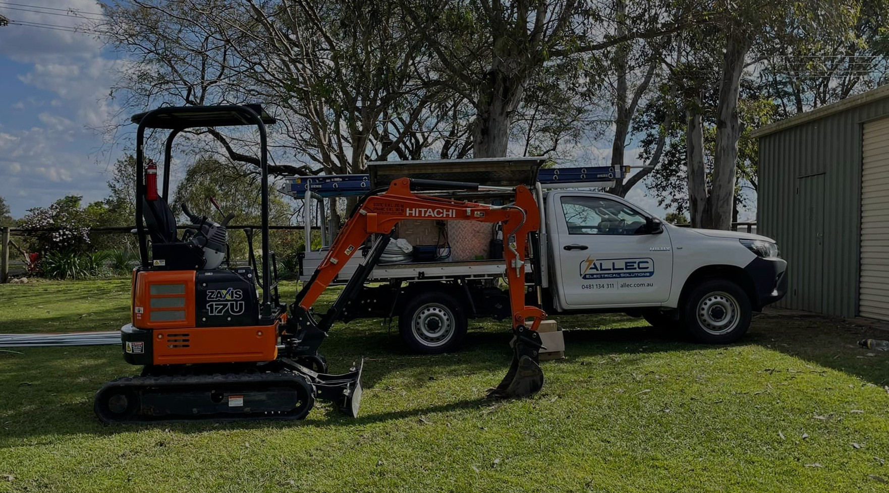 Allec Electrical Solutions branded car and excavator standing on a green grass.