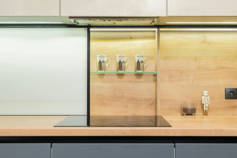 Cook top under decorative mugs in contemporary kitchen